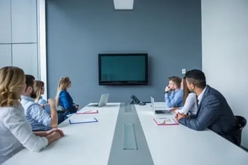 Fotografía de un equipo corporativo reunido en una sala de juntas atendiendo una presentación de un CMMI Licensed Partner
